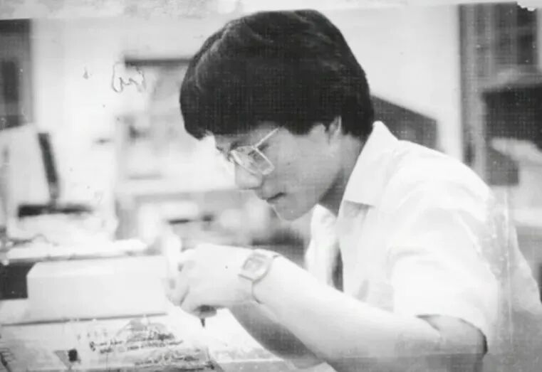 Jensen Huang, early years engineer - man wearing glasses writing on paper.