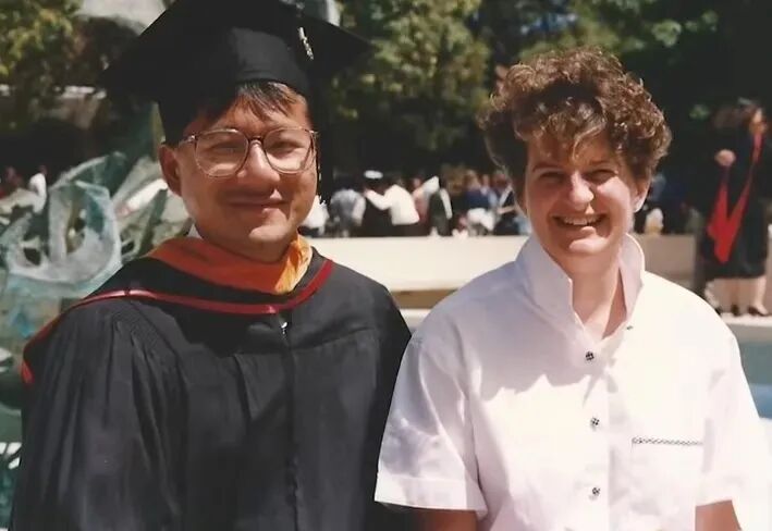 Jenson Huang and Lori, man and woman smiling in graduation gowns.