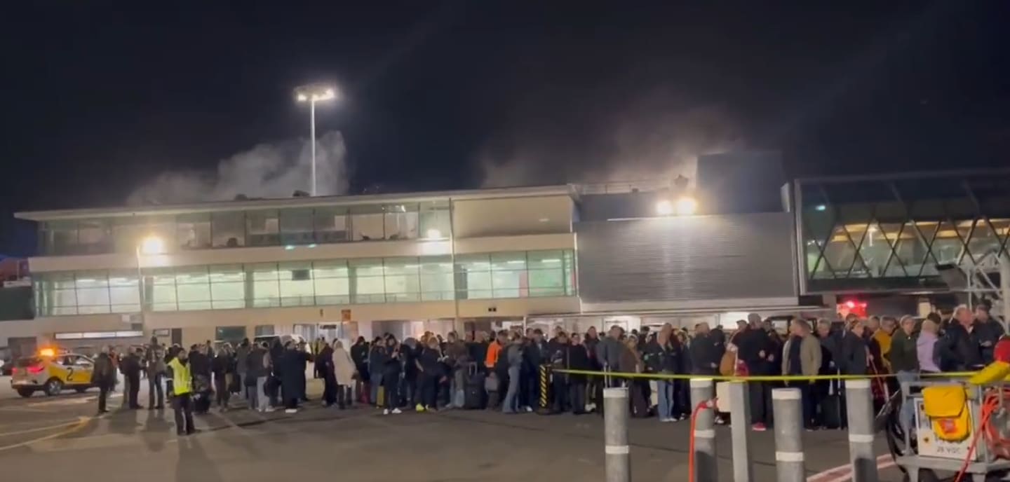 Crowds pictured on the tarmac at Wellington Airport after a fire in the domestic terminal sparked evacuations. 