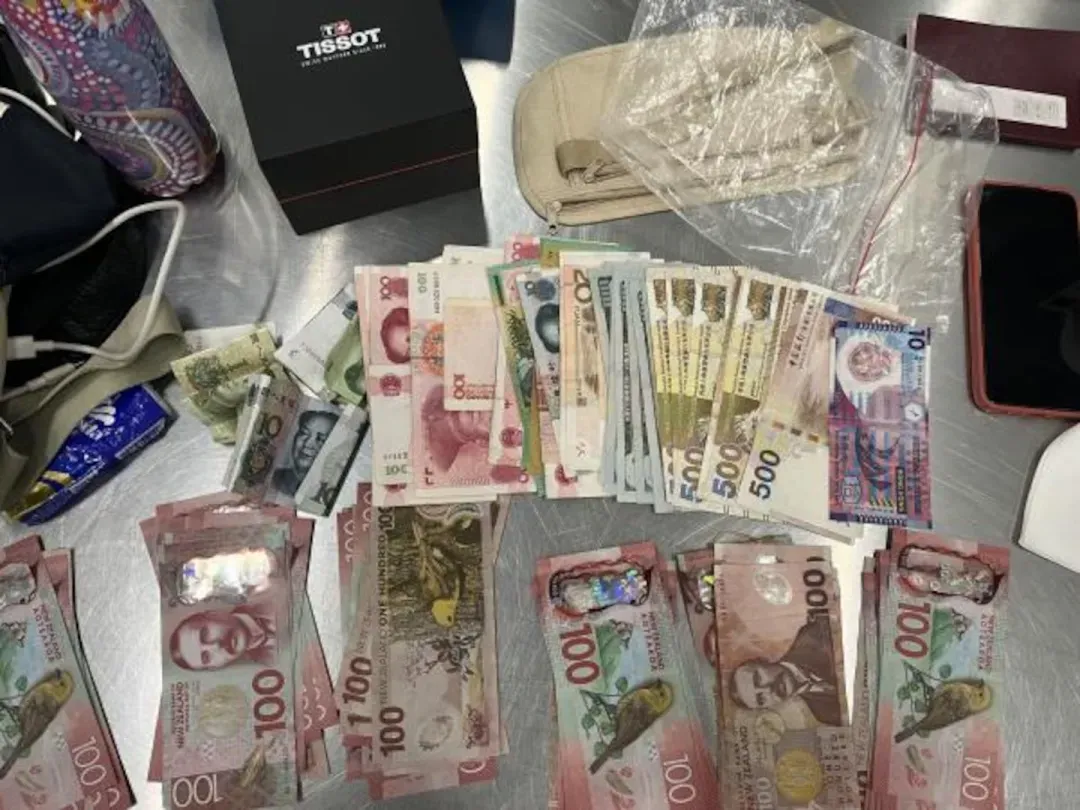 Cash believed to have been collected from victims was seized from the accused trio after they were arrested by Auckland City Financial Crime Unit detectives. Photo / NZ Police