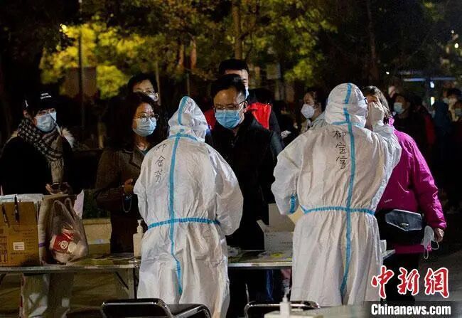 10月21日凌晨,兰州市城关区居民在一处临时搭建的核酸检测点排队做检测。 高展 摄 Image