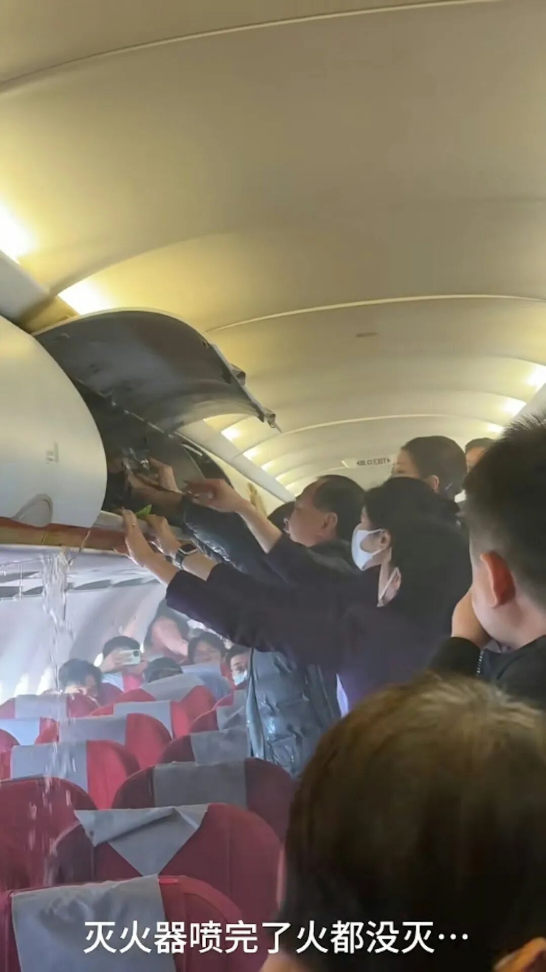 乘客及空姐不斷向行李架倒水滅火。（影片截圖）