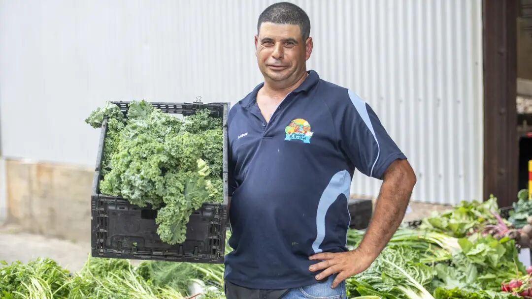 种植户安德鲁·马斯卡特在卡里奇沃克斯农贸市场的摊位前。照片由杰里米·派珀拍摄。